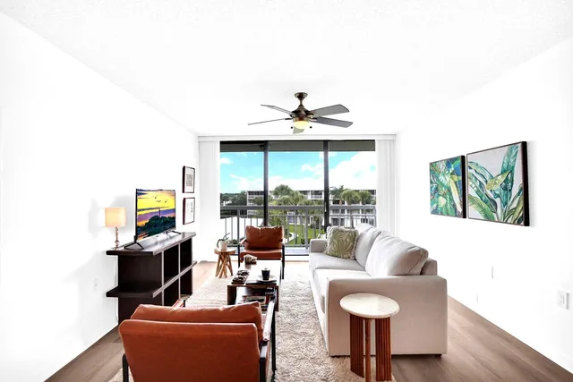 a living room with furniture and a floor to ceiling window