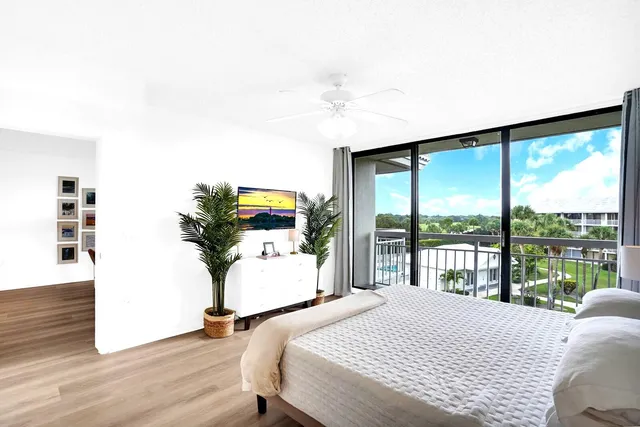 a bedroom with a bed and large windows
