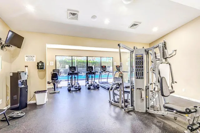 a living room with furniture gym equipment and a large window