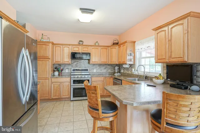 a kitchen with granite countertop a stove a sink and a refrigerator