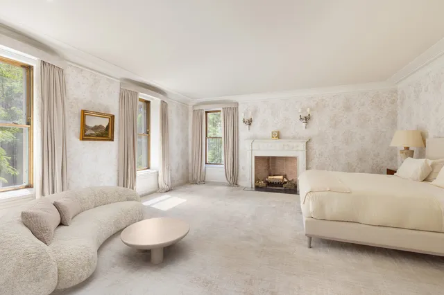 a spacious bedroom with a bed and a fireplace