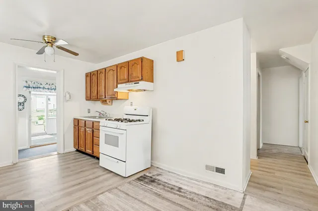 a kitchen with cabinets appliances and wooden floor