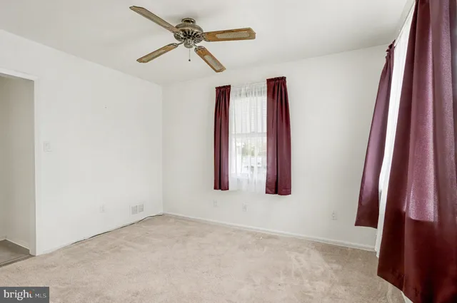 a view of a room with window and a ceiling fan