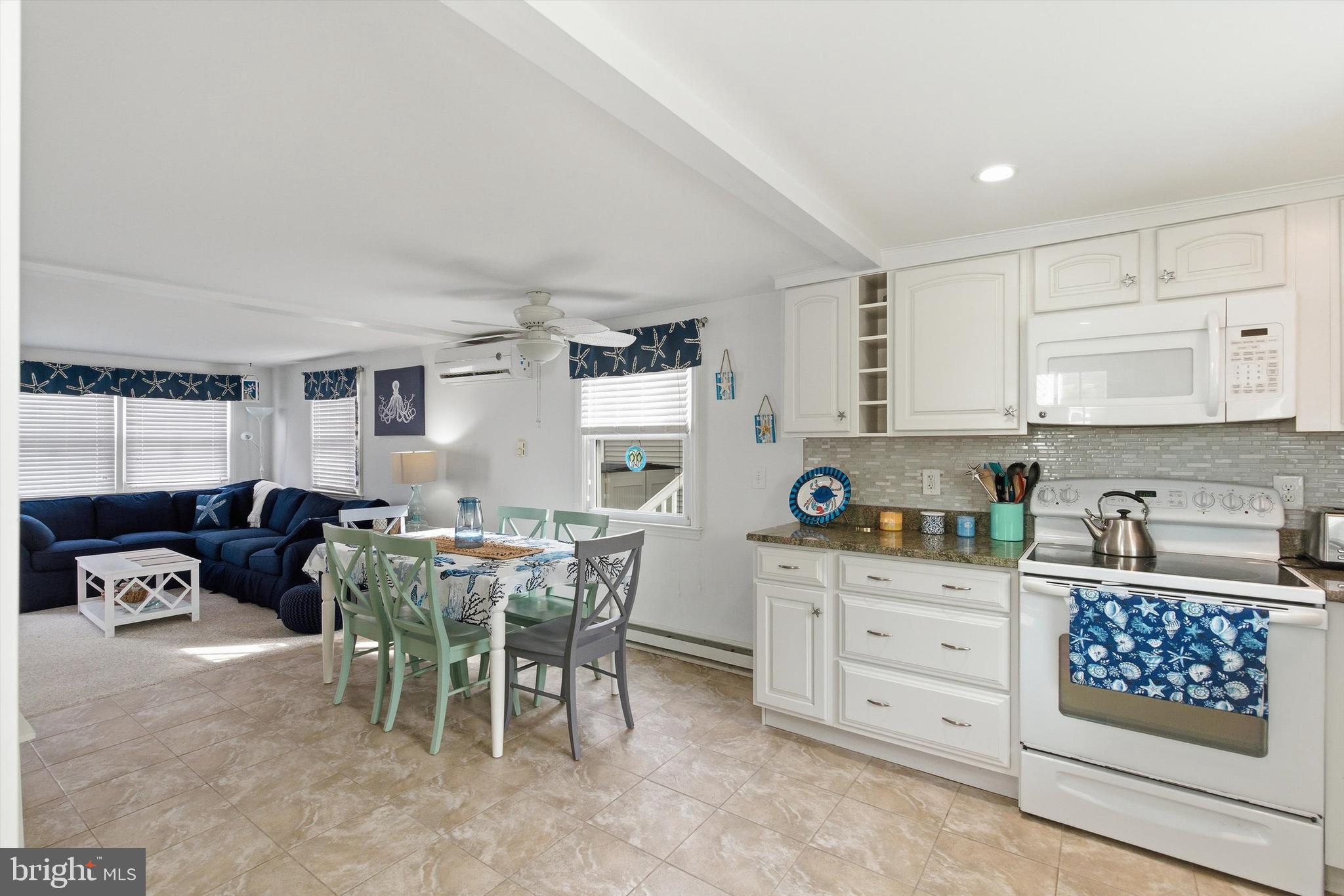 2 West Janet Road, Unit 1 Long Beach Township, NJ 08008 - Photo 13 of 36 a kitchen with stainless steel appliances kitchen island granite countertop a table chairs and a refrigerator