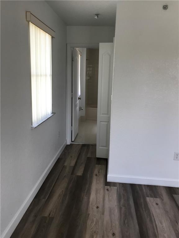 4331 Southwest 160th Avenue, Unit 200 Miramar, FL 33027 - Photo 14 of 19 an empty room with wooden floor and windows