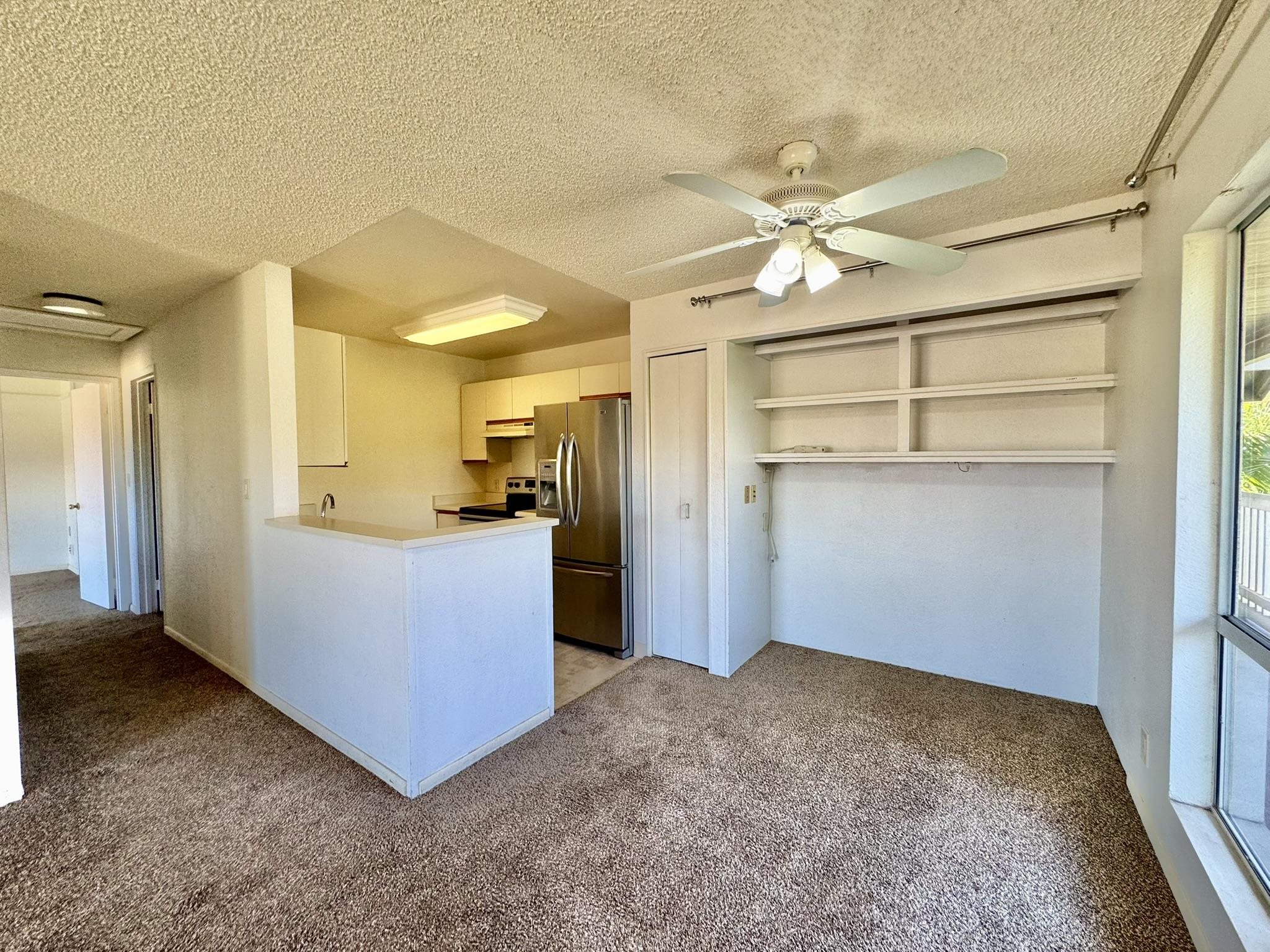 a view of a kitchen with a refrigerator and a ceiling fan