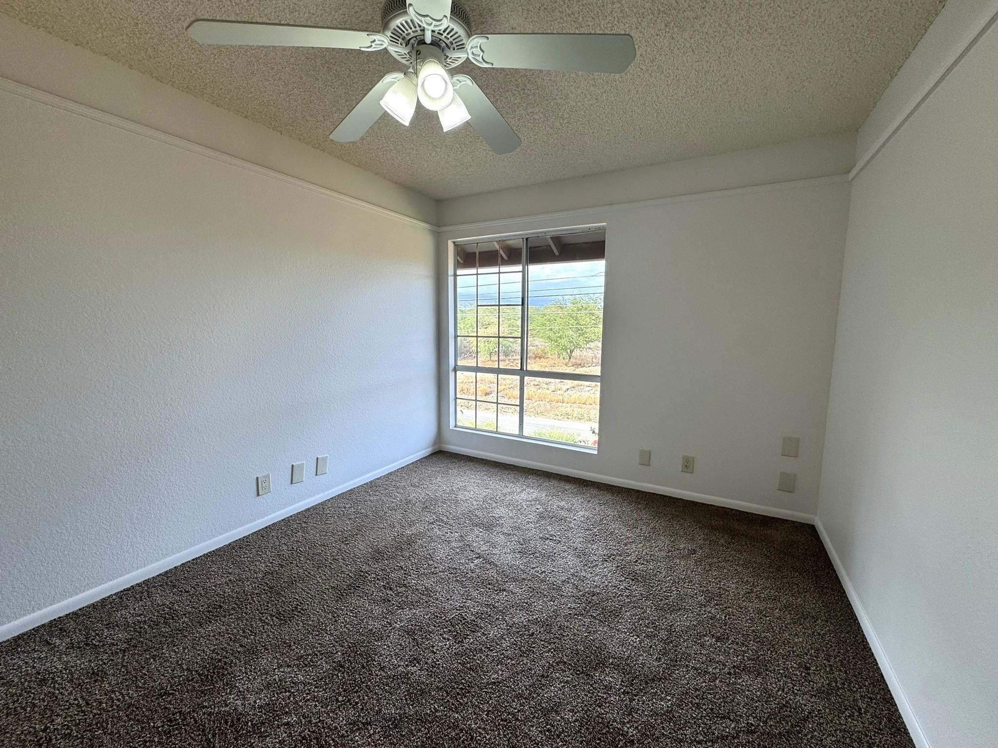 140 Uwapo Road, Unit 56204 Kihei, HI 96753 - Photo 12 of 40 an empty room with a chandelier fan and windows