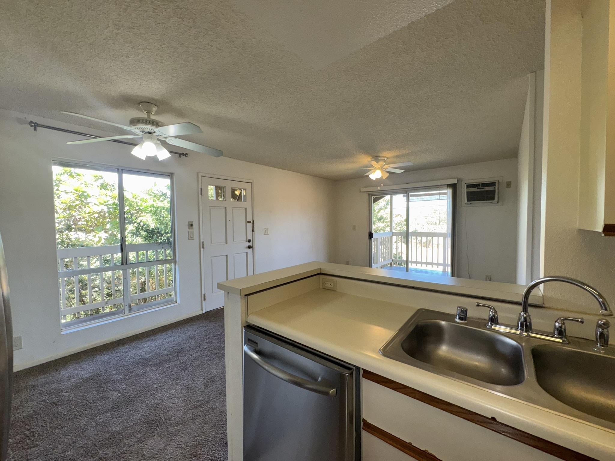 140 Uwapo Road, Unit 56204 Kihei, HI 96753 - Photo 2 of 40 a view of a kitchen with a sink and dishwasher next to a window