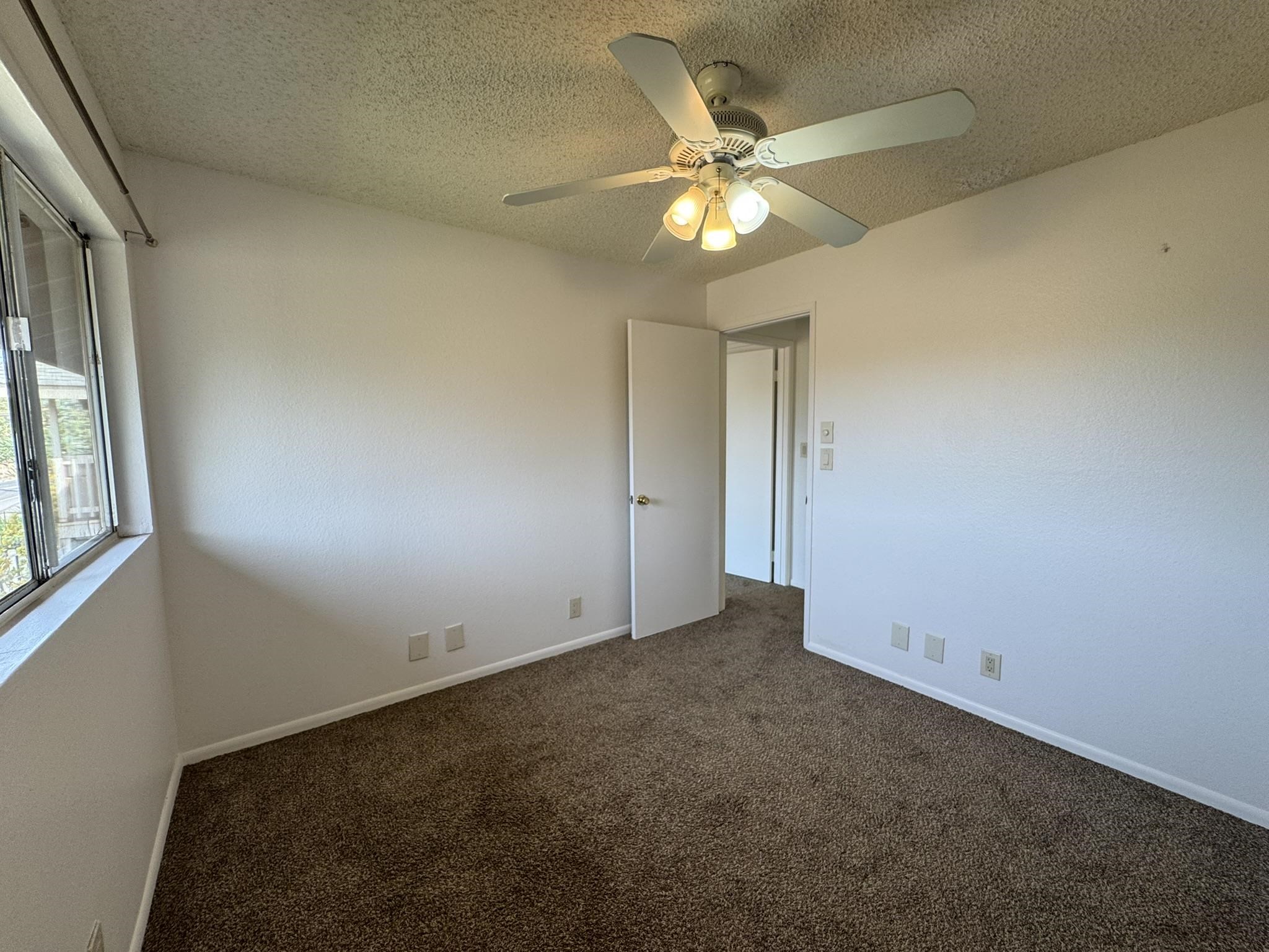 140 Uwapo Road, Unit 56204 Kihei, HI 96753 - Photo 22 of 40 an empty room with a chandelier fan and windows