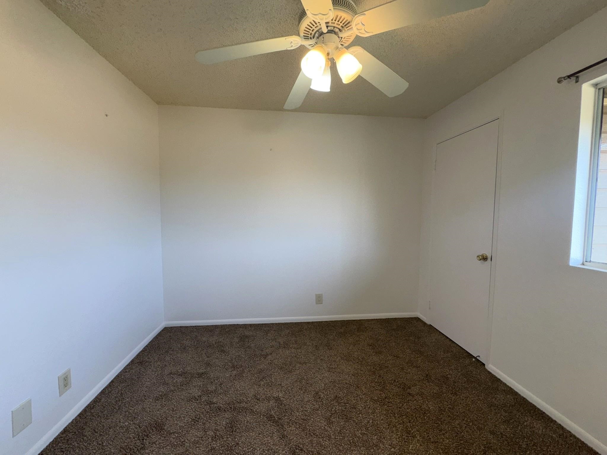 140 Uwapo Road, Unit 56204 Kihei, HI 96753 - Photo 23 of 40 an empty room with a chandelier fan and windows