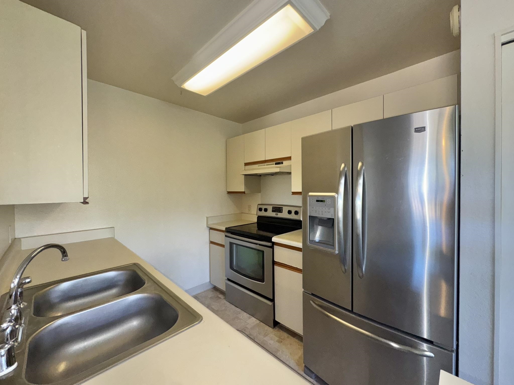 140 Uwapo Road, Unit 56204 Kihei, HI 96753 - Photo 5 of 40 a kitchen with stainless steel appliances granite countertop a refrigerator and a stove