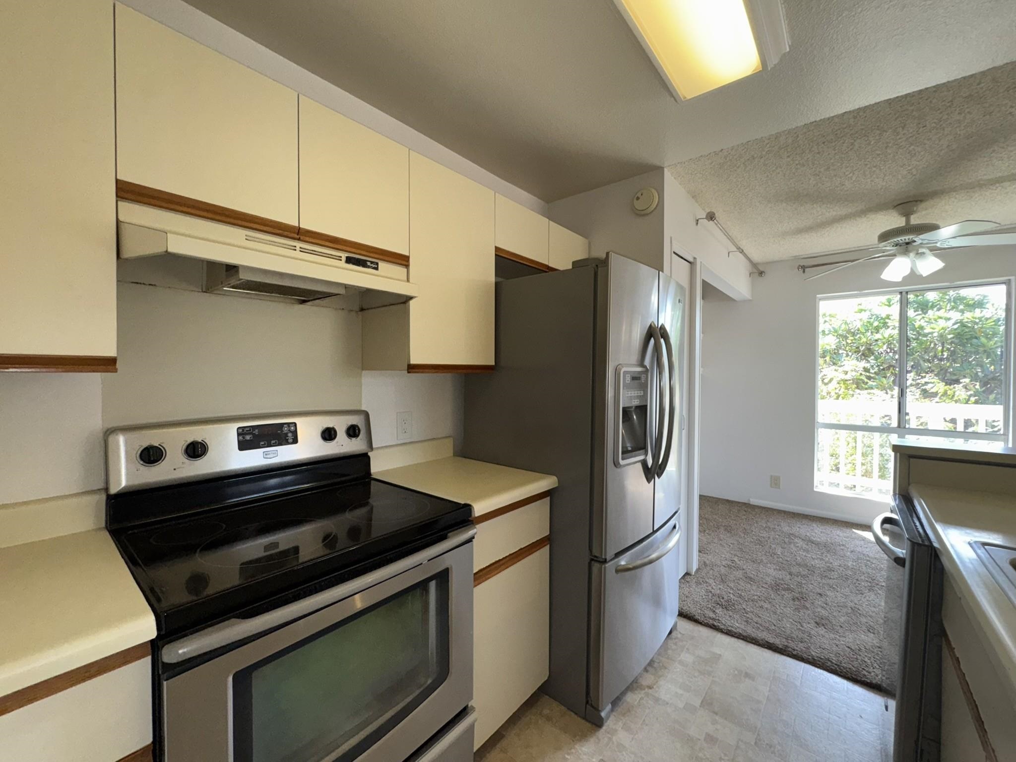 140 Uwapo Road, Unit 56204 Kihei, HI 96753 - Photo 9 of 40 a kitchen with stainless steel appliances a stove a sink and a refrigerator