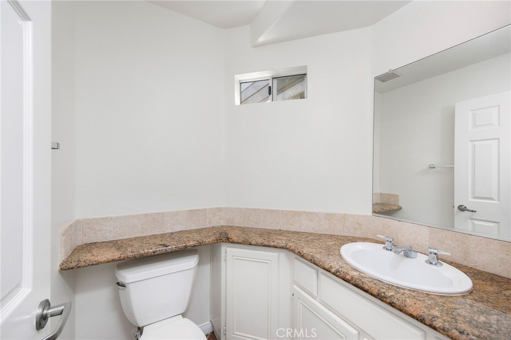 33072 Ocean Ridge Dana Point, CA 92629 - Photo 7 of 26 a bathroom with a granite countertop sink a toilet and mirror
