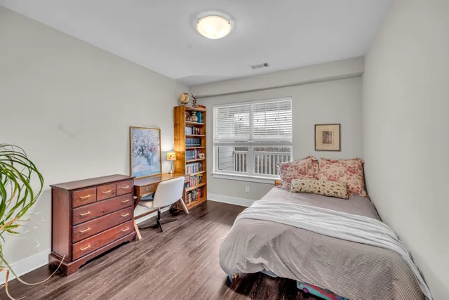 a bedroom with a bed and wooden floor