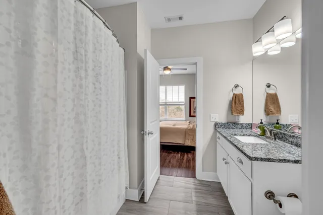 a en suite bathroom with a granite countertop sink and a mirror