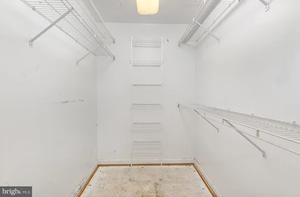 a view of walk in closet with empty racks