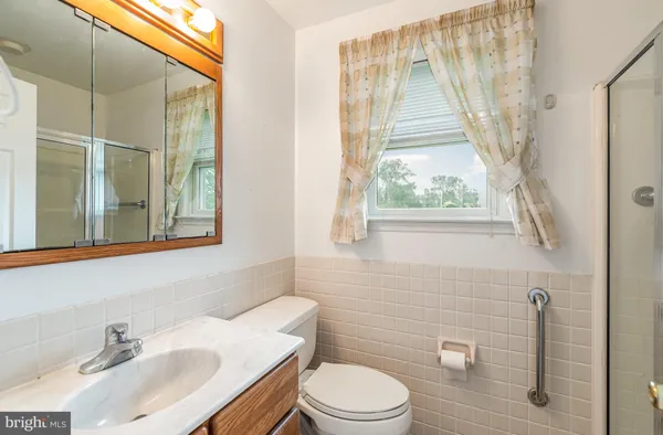 a bathroom with a sink toilet a mirror and shower