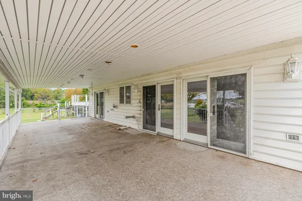 a view of an empty room with a sliding door and balcony