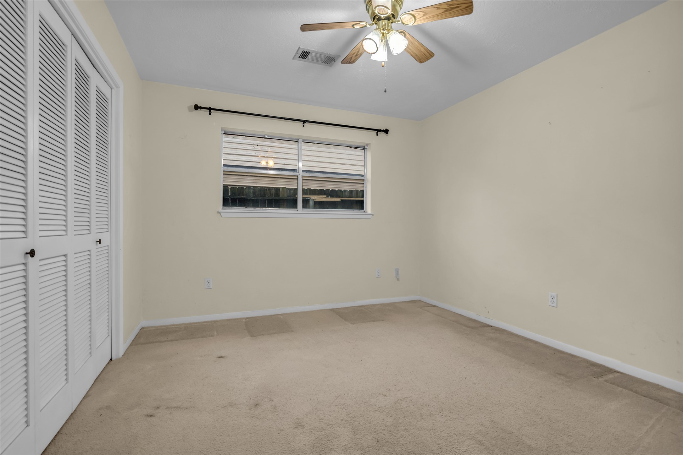 10002 Pinehurst Street Baytown, TX 77521 - Photo 14 of 17 an empty room with a chandelier fan and windows