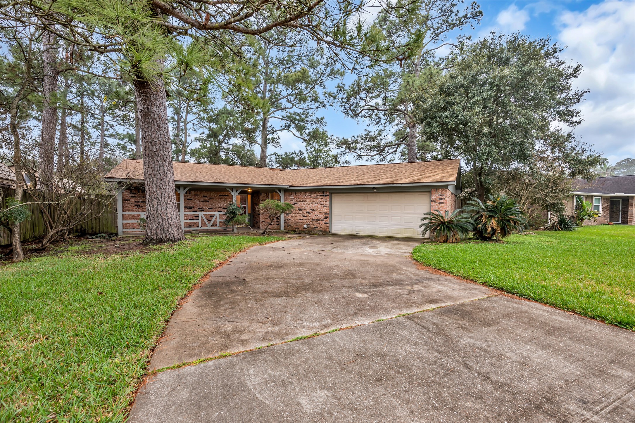 10002 Pinehurst Street Baytown, TX 77521 - Photo 2 of 17 a front view of a house with a yard and garage