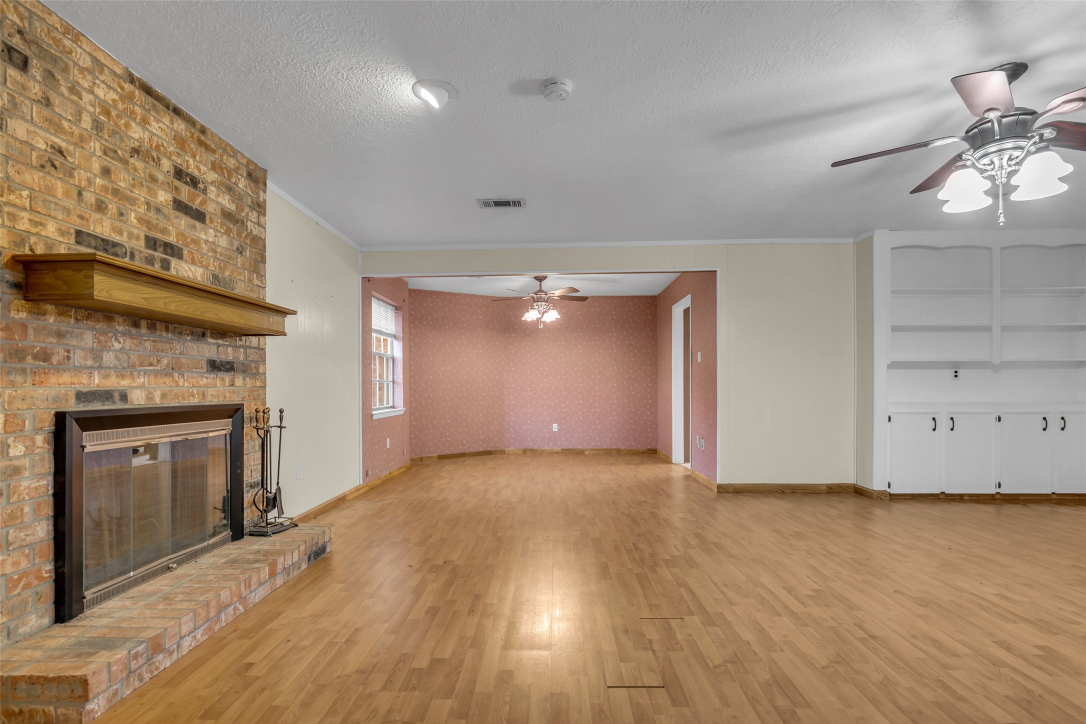 10002 Pinehurst Street Baytown, TX 77521 - Photo 5 of 17 an empty room with wooden floor fireplace and windows