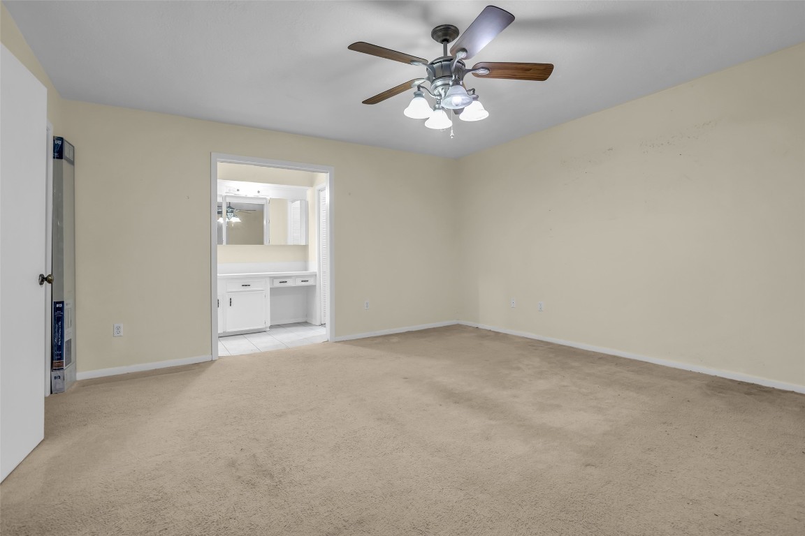 10002 Pinehurst Street Baytown, TX 77521 - Photo 10 of 17 an empty room with chandelier and windows