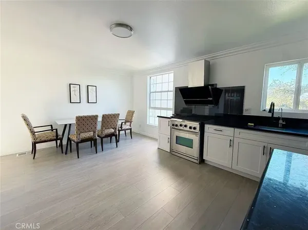 a kitchen with stainless steel appliances a microwave a sink a stove and white cabinets