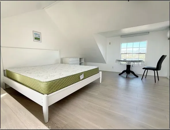 a bedroom with a bed and table chair