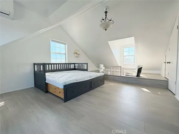 a spacious bedroom with a bed and a chandelier