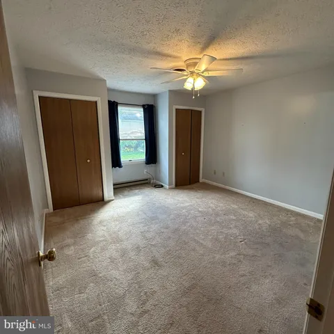 a view of an empty room with a chandelier fan