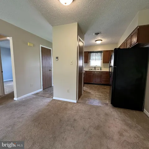 a kitchen with granite countertop a refrigerator and a sink
