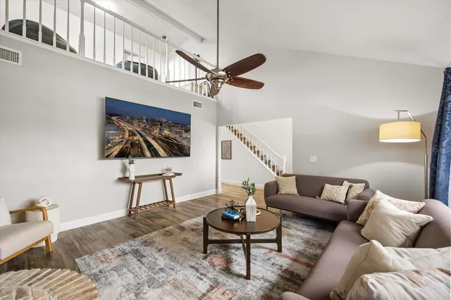 a living room with furniture a rug and a ceiling fan