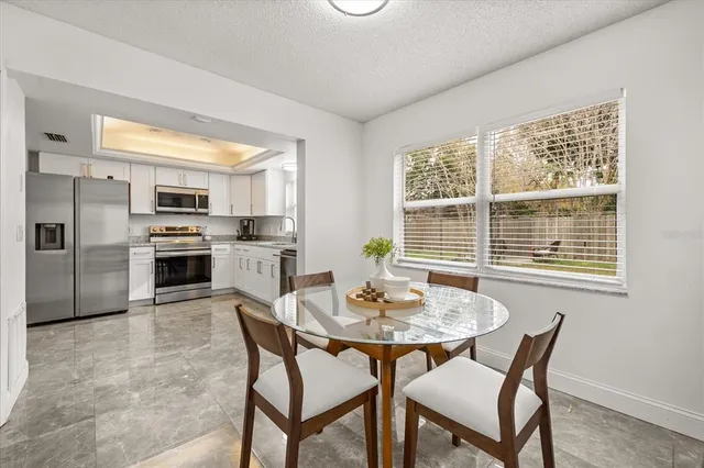 a kitchen with stainless steel appliances wooden floor dining table and chairs