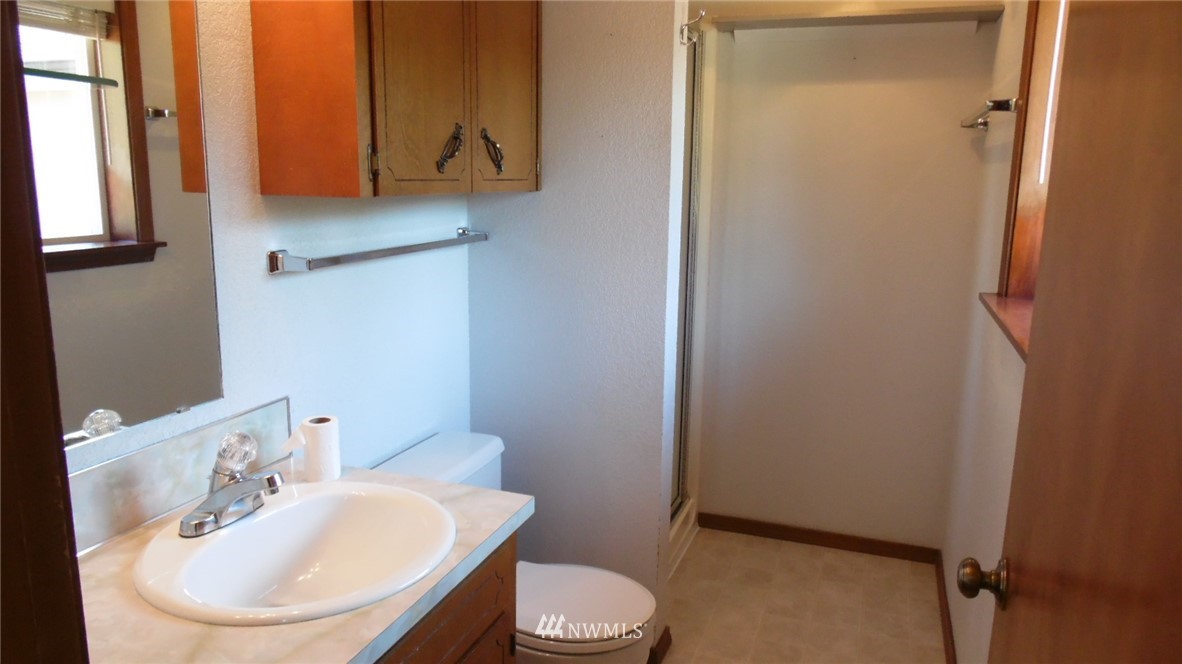 4538 180th Way Southwest Rochester, WA 98579 - Photo 11 of 25 a bathroom with a sink a toilet and mirror