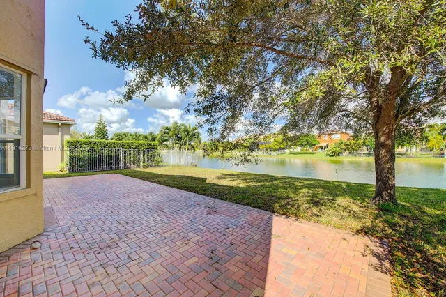 a view of a house with backyard and trees