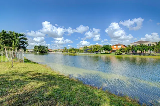 an aerial view of residential houses with outdoor space and lake view