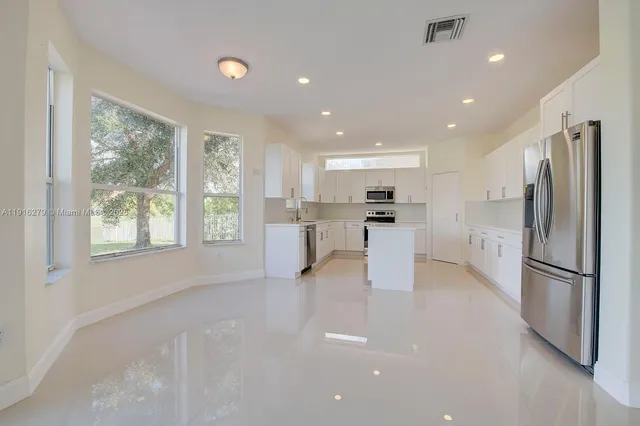 a kitchen with refrigerator and cabinets