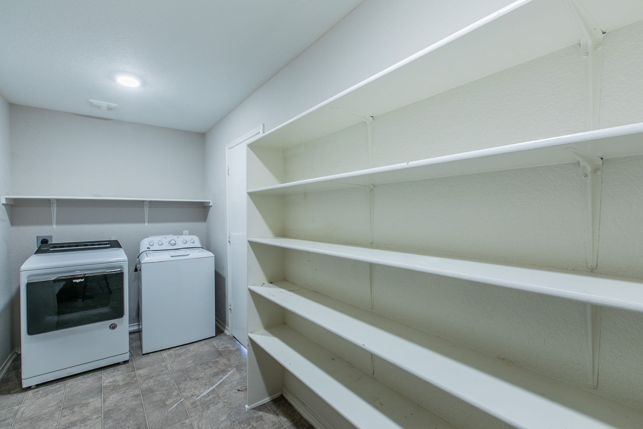 157 Lex Word Kyle, TX 78640 - Photo 12 of 34 Generous built-in shelving maximizes storage potential in this dedicated utility space with durable tile floors.