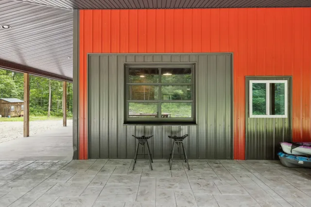a view of a porch with chairs and floor to ceiling window