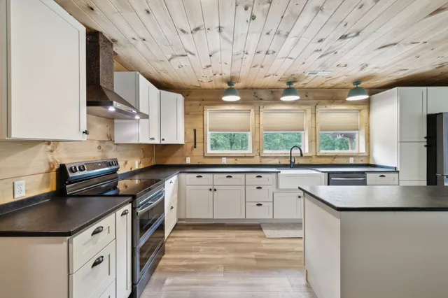 a kitchen with stainless steel appliances granite countertop a sink a stove and a refrigerator