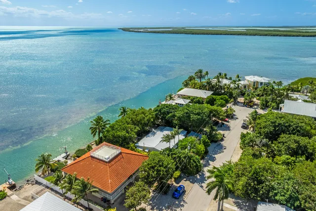a view of a street with a bench and trees around