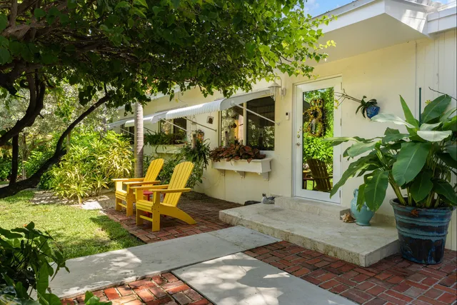 a view of yellow house with potted plants