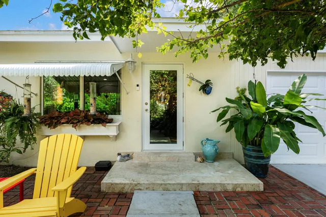 a view of a street with potted plants and large trees