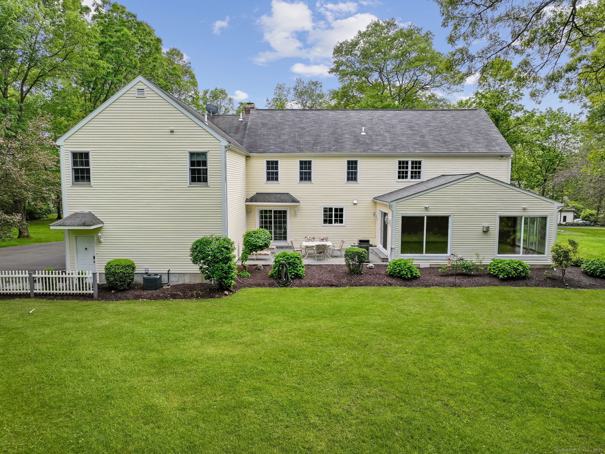 22 Fox Run Wilton, CT 06897 - Photo 4 of 40 a aerial view of a white house with a yard and table and chairs under an umbrella