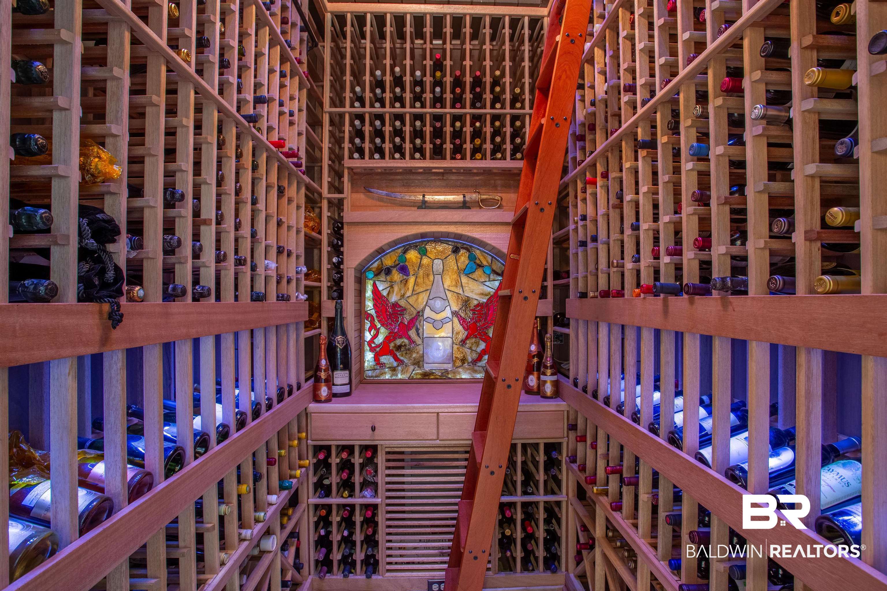 150 Austill Avenue Mobile, AL 36608 - Photo 18 of 39 Dedicated wine cellar featuring extensive wood racking, a rolling wood ladder, accent lighting, a stained glass art piece, and integrated cabinetry