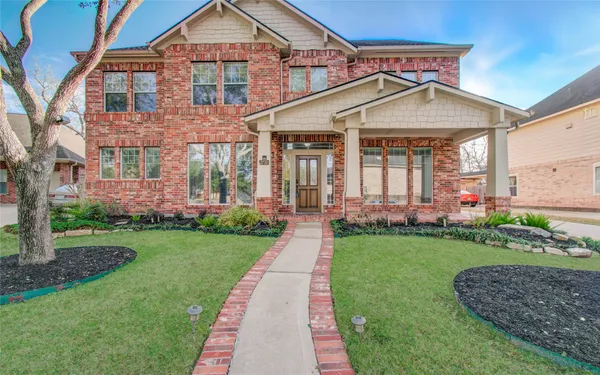 a front view of a house with a yard and potted plants