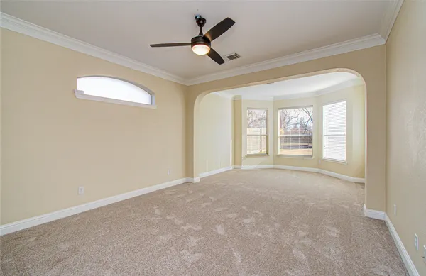 en empty room with windows and fan