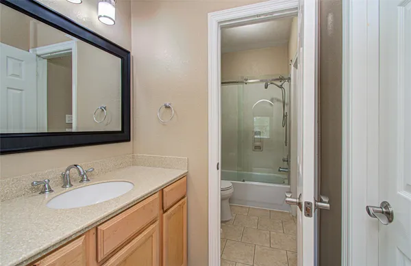 a bathroom with a granite countertop sink vanity and mirror