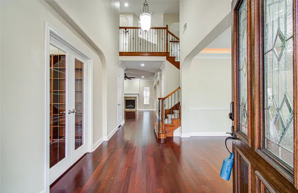 a view of a hallway with wooden floor and staircase