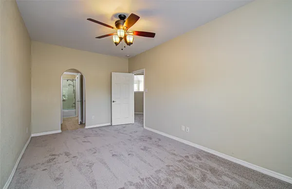 wooden floor in an empty room with a chandelier fan